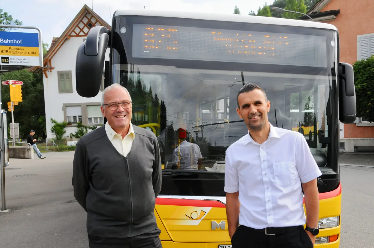 Karl Schlegel (links) und Mehmeti Refki transportieren den ganzen Tag Turner und Zuschauer. Zwei Busfahrer vor einem der Spezialkurs-Postautos.
